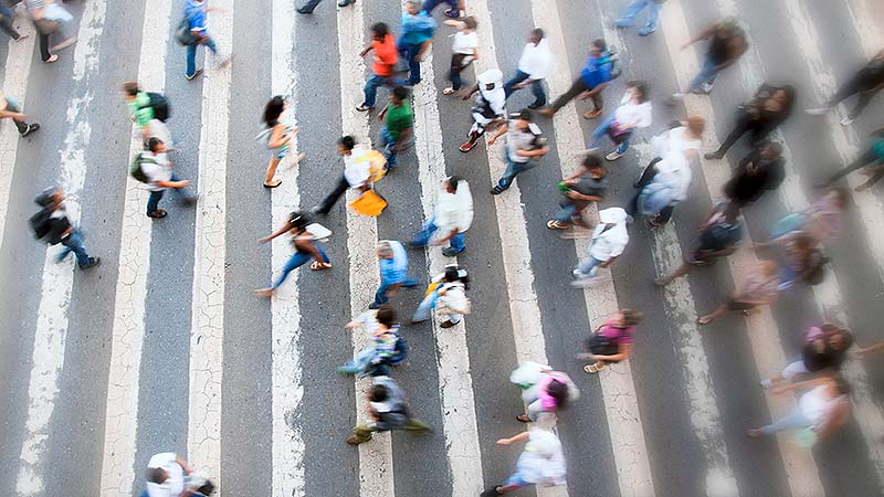 Pedestrians crossing a street at a crosswalk.
